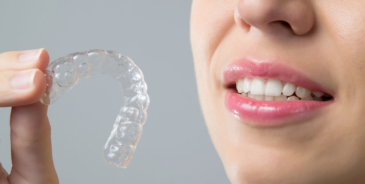 woman holding up invisalign